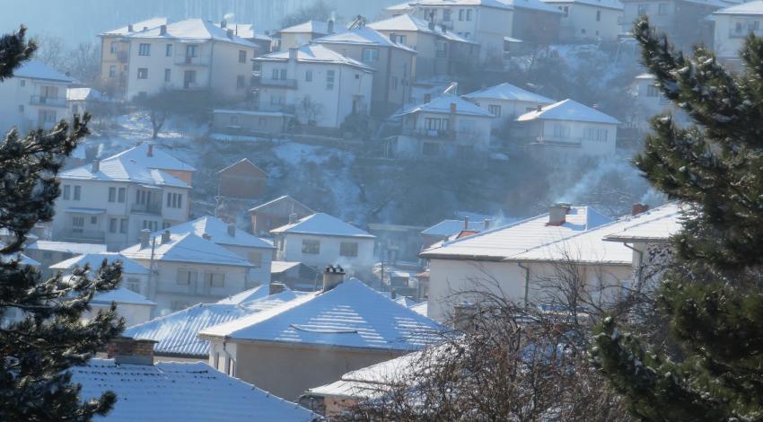 A peak through the trees at the snowy town sloping up the Krusevo hills.